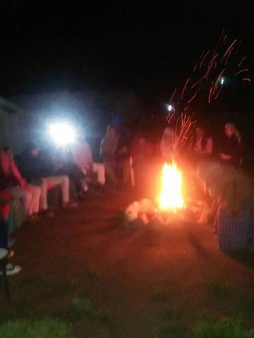 Menschen genießen ein Lagerfeuer im Freien bei Nacht mit Funkenflug