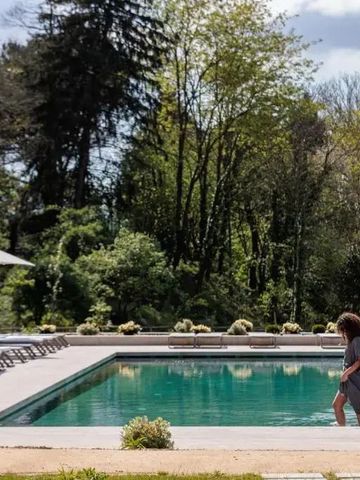 Frau am Pool inmitten einer grünen Gartenanlage.