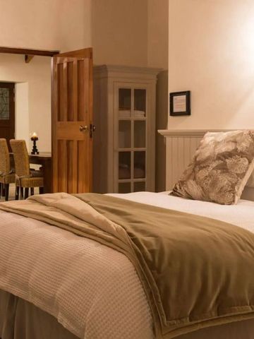 Komfortables Schlafzimmer mit Doppelbett und eleganter Bettwäsche in sanften Erdtönen