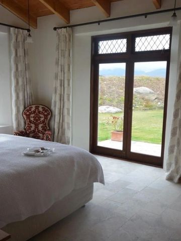 Helles Schlafzimmer mit großem Fenster und Aussicht auf Gartenlandschaft