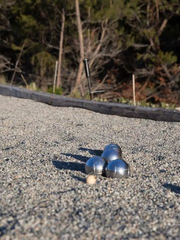 Petanqueplatz im Freien mit Kiesfläche und Kugeln im Spiel