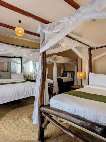 Geräumiges Zimmer mit zwei Betten und weißen Moskitonetzen