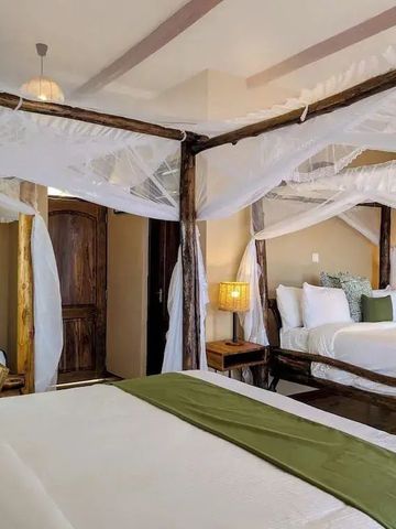 Doppelbett mit weißem Baldachin und Holzmöbeln