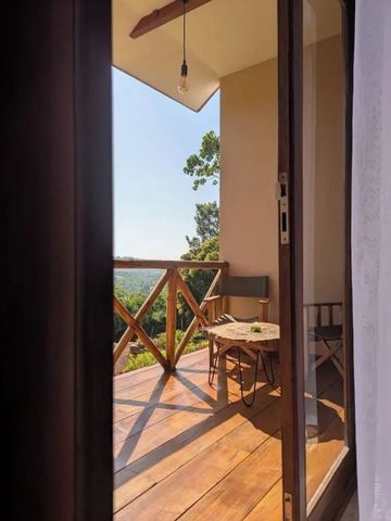 Holzterrasse mit Sitzgelegenheit und Blick auf grüne Landschaft
