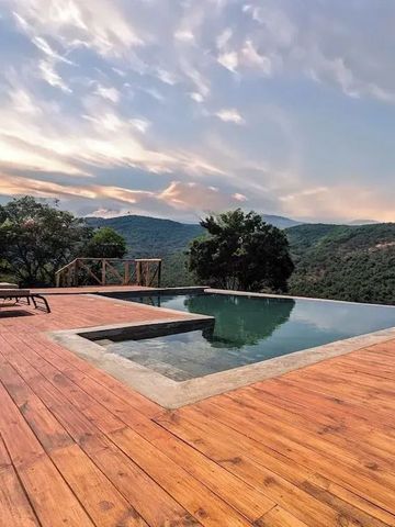Infinity Pool mit Blick auf die grüne Landschaft und bewölkten Himmel