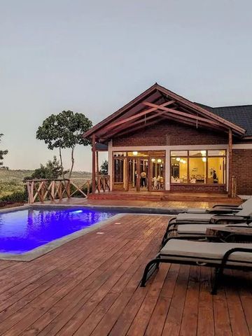 Beleuchteter Pool vor einem eleganten Haus in der Dämmerung