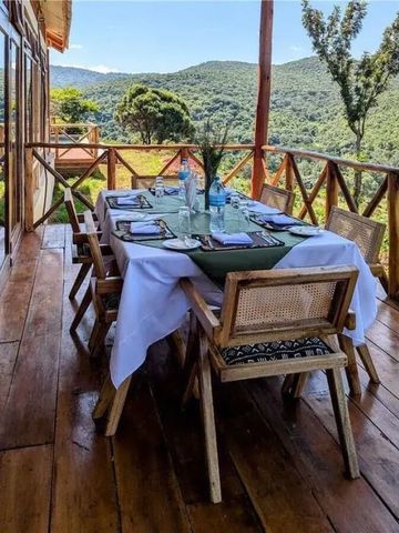 Eleganter Esstisch auf Terrasse mit Blick auf grüne Hügel