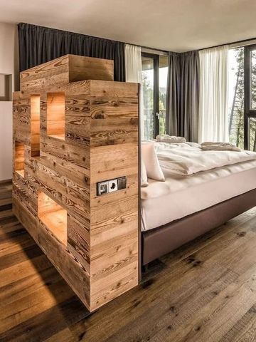 Stilvoll möbliertes Schlafzimmer mit großen Fenstern und Blick ins Grüne