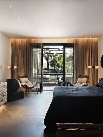 Geräumiges Hotelzimmer mit großem Bett und stilvoller Einrichtung, Blick auf Garten.