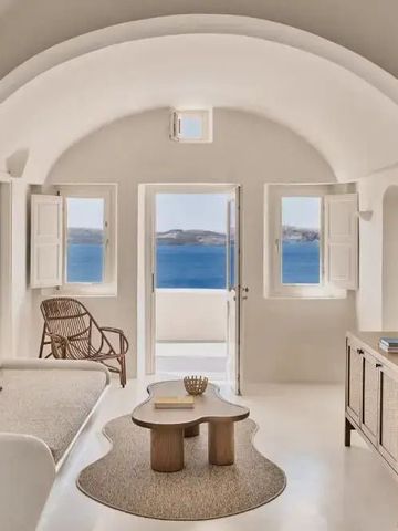 Eleganter Wohnbereich mit Blick auf das Meer durch weiße Fenster und Türen