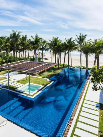 Poolbereich mit Blick auf den Strand und Palmen unter klarem Himmel