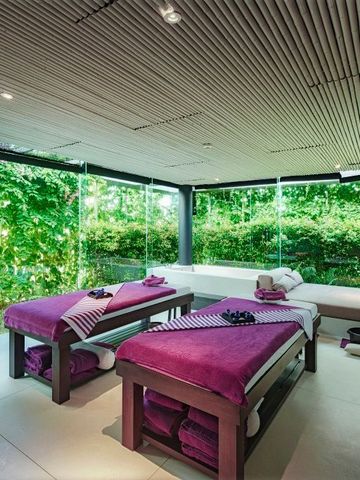 Luxuriöser Spa-Raum mit zwei Massagetischen und großer Fensterfront