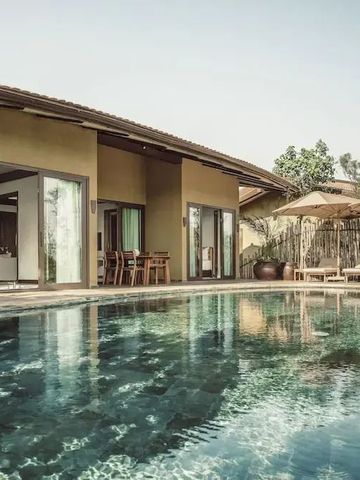 Villa mit großzügigem Pool und Liegebereich in einer tropischen Umgebung