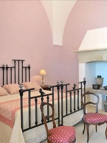 Schlafzimmer im Naturalis Bio Resort mit klassischem Kamin und rosa Wänden