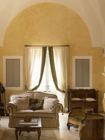 Opulentes Wohnzimmer im Naturalis Bio Resort mit hohen Decken und eleganten Sofas