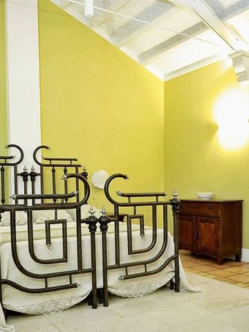 Gemütliches Schlafzimmer im Naturalis Bio Resort mit antikem Bettgestell und gelben Wänden