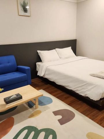 Gemütliches Hotelzimmer mit Doppelbett und blauer Couch