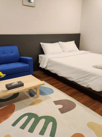 Modernes Hotelzimmer mit Doppelbett und blauer Couch