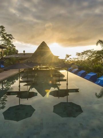 Infinity-Pool bei Sonnenuntergang mit Palmen und stimmungsvoller Atmosphäre