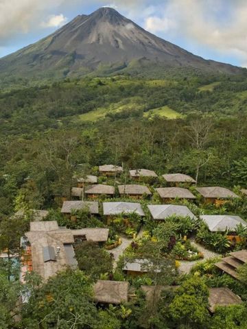 Luftaufnahme des Hotels in üppiger Landschaft mit Vulkan im Hintergrund