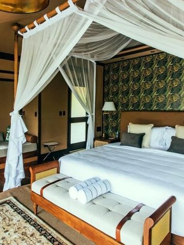 Gemütliches Schlafzimmer mit Himmelbett und exotischer Dekoration im Zeltlagerstil