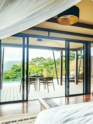 Aussicht vom Schlafzimmer auf die private Terrasse mit Essbereich und Blick auf die Natur