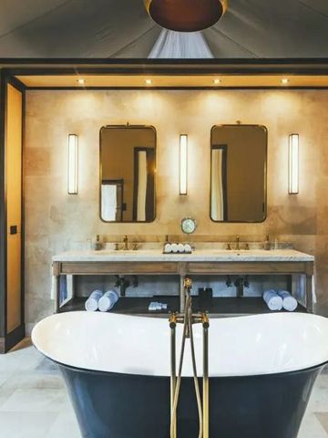 Modernes Badezimmer mit großer freistehender Badewanne und stilvoller Beleuchtung