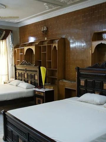 Großes Zimmer mit zwei Betten und eleganten Holzelementen