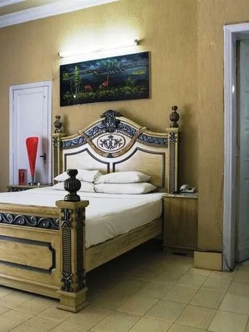 Elegantes Schlafzimmer mit kunstvoll designtem Holzbett und stilvollen Möbeln