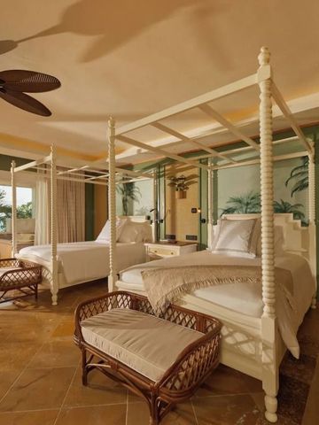 Doppelzimmer mit zwei Himmelbetten und tropischer Dekoration.