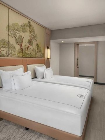 Helles Zimmer mit stilisierten Kunstwerken neben zwei Einzelbetten