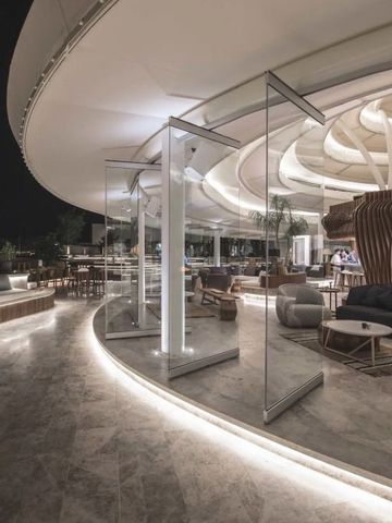 Stilvolle Lounge des Hotels mit geschwungenen Linien und eleganter Beleuchtung bei Nacht