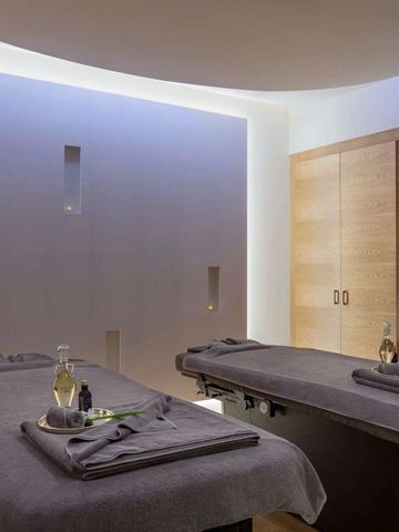 Luxuriöser Spa-Behandlungsraum mit zwei Massagetischen und gedämpfter Beleuchtung
