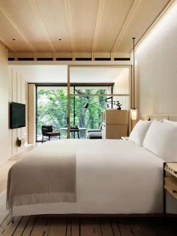 Stilvolles Schlafzimmer mit sanfter Beleuchtung und Waldsicht