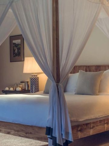 Gemütliches Schlafzimmer mit Himmelbett und sanfter Beleuchtung