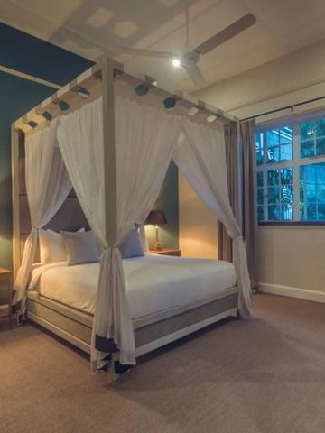 Schlafzimmer mit Himmelbett und warmem Lichtambiente