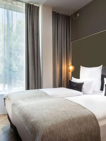 Modernes Hotelzimmer mit zwei Einzelbetten und großen Fenstern