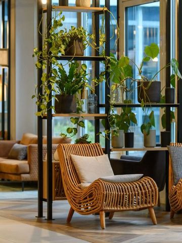 Helle Lobby mit modernen Rattanmöbeln und Pflanzen