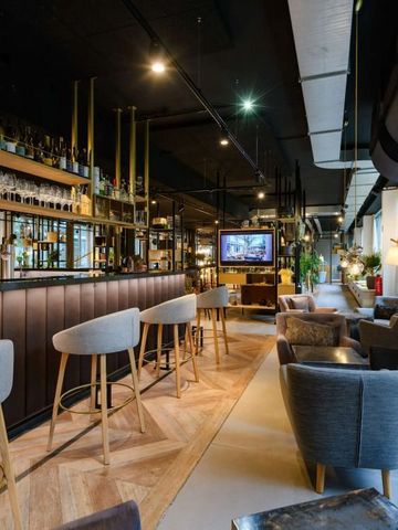 Elegante Bar mit modernen Sitzmöbeln und vielen Flaschen im Hintergrund