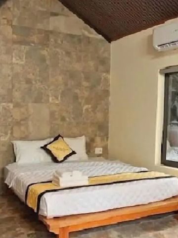 Schlafzimmer mit Steinwänden und großen Fenstern