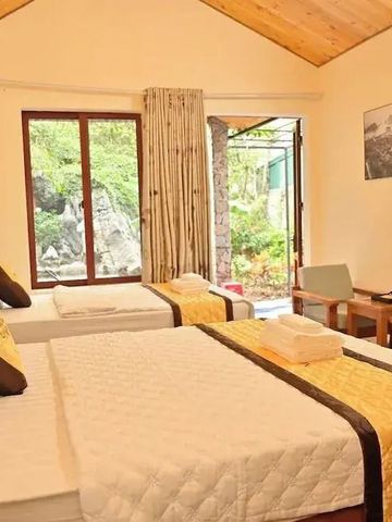 Doppelzimmer mit Holzmöbeln und großem Fenster