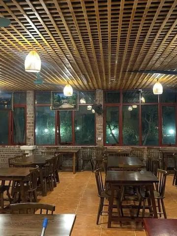 Stilvoller Essbereich mit Holzmöbeln und gedämpfter Beleuchtung im Hotel Jiva Hoa Lu Retreat