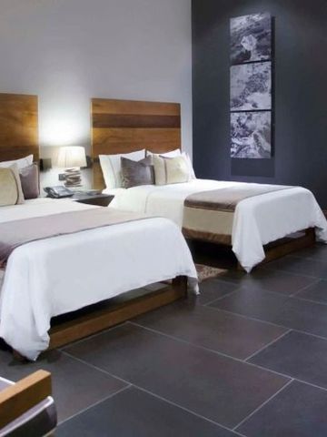 Modernes Doppelzimmer mit zwei großen Betten und stilvollem Interieur