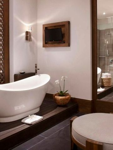 Luxuriöses Badezimmer mit freistehender Badewanne und eleganten Holzakzenten