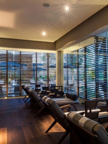 Entspannungsraum mit Holzmöbeln und großen Fenstern im Spa-Bereich