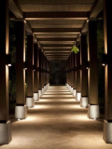 Beleuchteter Korridor mit Holzelementen und Pflanzen