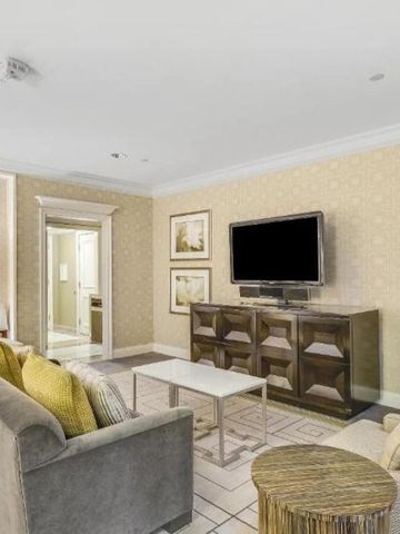 Elegantes Wohnzimmer in einer Hotelsuite mit Sofa und Flachbildfernseher.