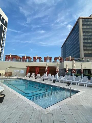 Dachterrasse mit Außenpool und Liegestühlen unter blauem Himmel.
