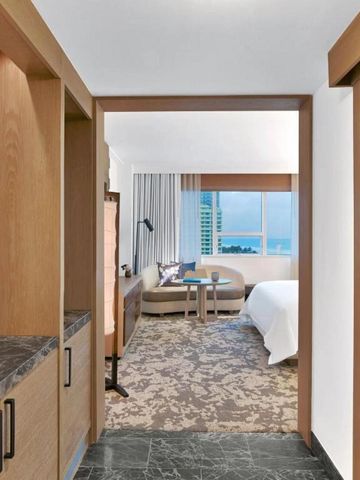 Heller Korridor mit Blick in ein komfortables Hotelzimmer mit Meeresblick