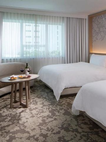 Elegantes Hotelzimmer mit zwei Betten und gemütlichem Sitzbereich